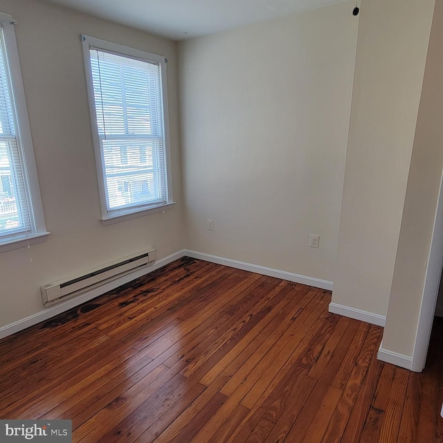 unfurnished room featuring plenty of natural light, dark hardwood / wood-style flooring, and a baseboard radiator