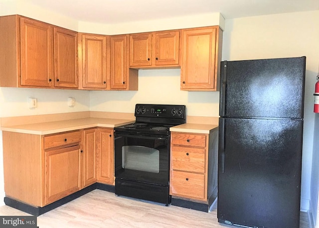 kitchen featuring light hardwood / wood-style flooring and black appliances