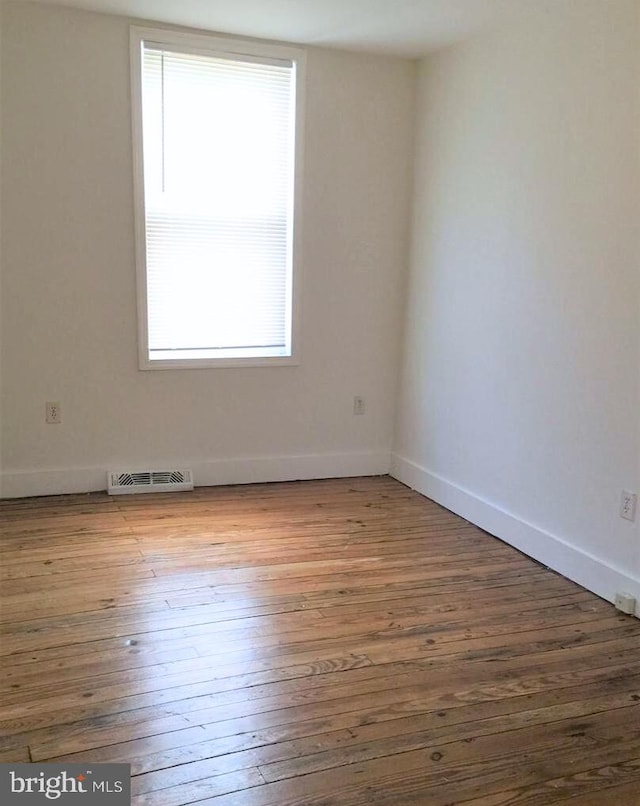 spare room with hardwood / wood-style flooring and a wealth of natural light