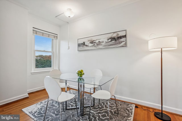 dining area featuring hardwood / wood-style flooring and ornamental molding