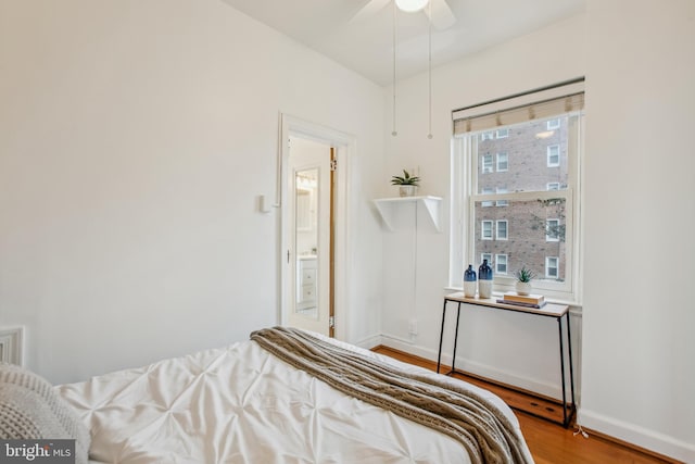 bedroom featuring ensuite bathroom, wood-type flooring, multiple windows, and ceiling fan