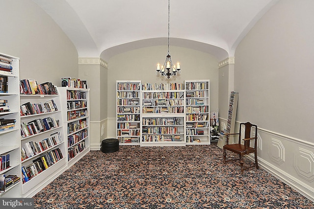 sitting room featuring carpet, built in features, lofted ceiling, and a notable chandelier