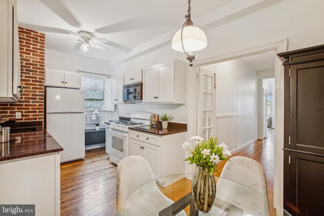 kitchen with light hardwood / wood-style floors, ceiling fan, decorative light fixtures, white appliances, and white cabinets