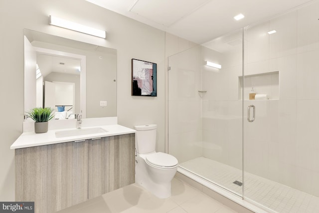 bathroom with toilet, vanity, tile patterned floors, and a shower with shower door