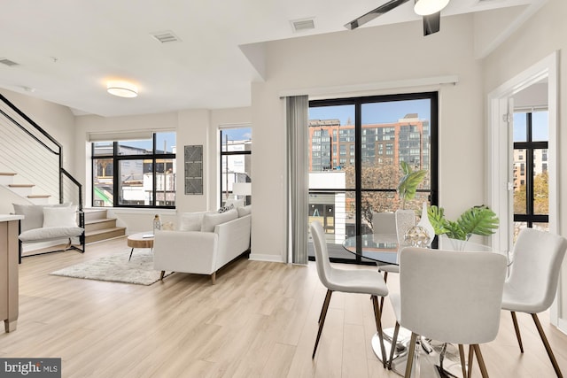 dining space with light hardwood / wood-style flooring and ceiling fan