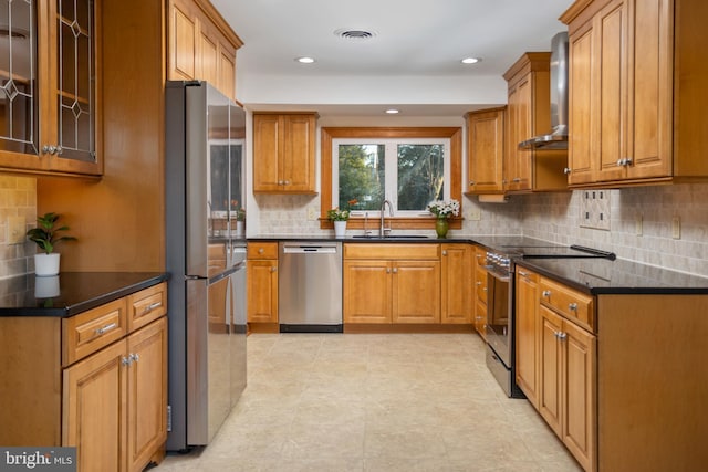 kitchen featuring appliances with stainless steel finishes, light tile patterned floors, sink, wall chimney range hood, and tasteful backsplash