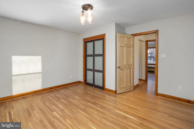 unfurnished room featuring light wood-type flooring and radiator heating unit