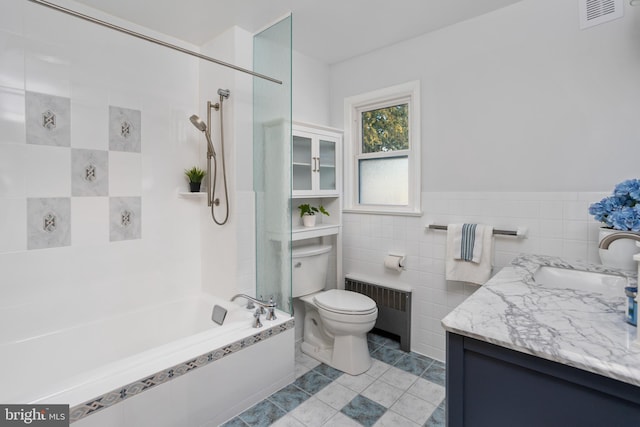 full bathroom featuring toilet, tile walls, tile patterned floors, radiator heating unit, and vanity