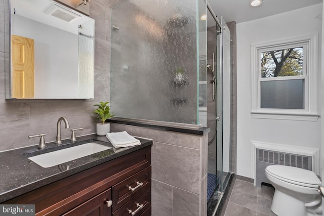 bathroom with tile patterned flooring, toilet, radiator heating unit, a shower with door, and vanity