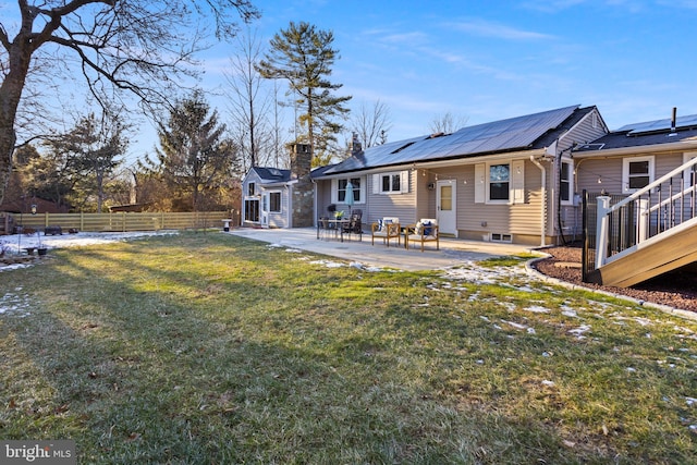 back of house with a lawn, solar panels, and a patio