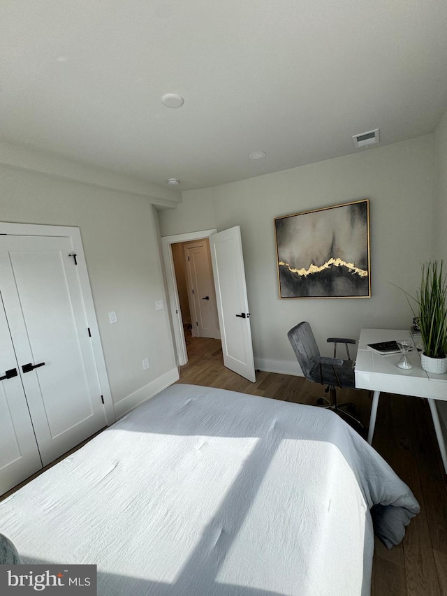 bedroom with wood-type flooring and a closet