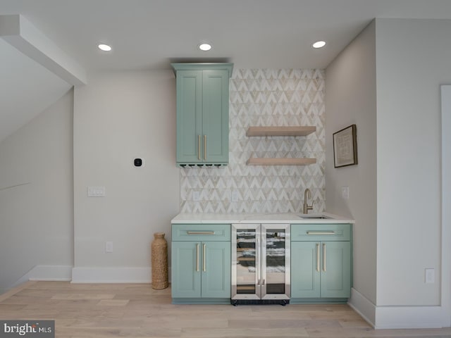 bar featuring light hardwood / wood-style floors, wine cooler, sink, and tasteful backsplash