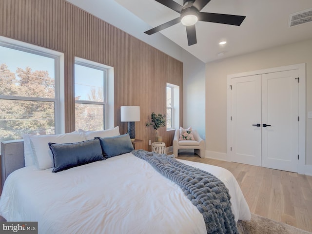 bedroom featuring ceiling fan, a closet, and light hardwood / wood-style flooring