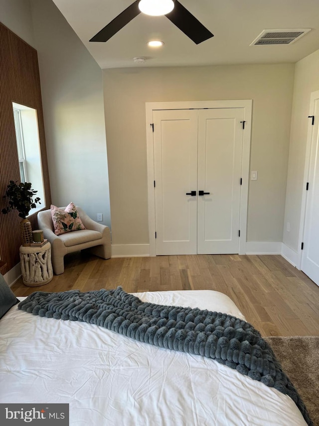 bedroom featuring light wood-type flooring, ceiling fan, and a closet