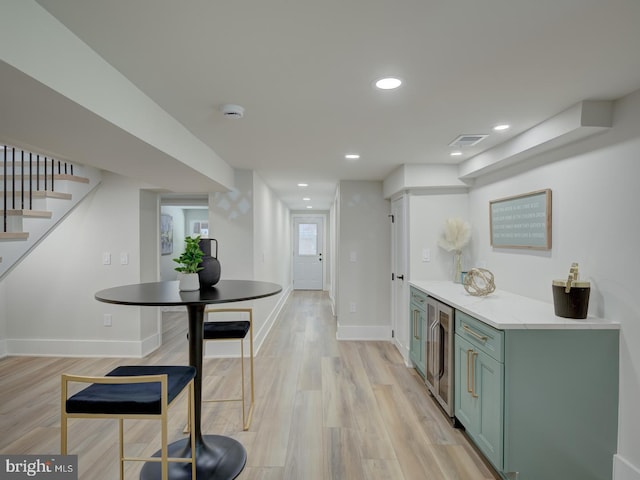 kitchen featuring light hardwood / wood-style floors, wine cooler, and green cabinetry