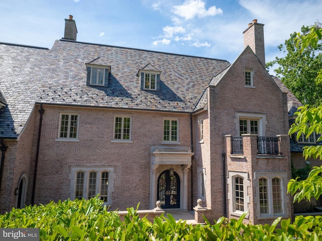 view of front facade featuring a balcony and french doors