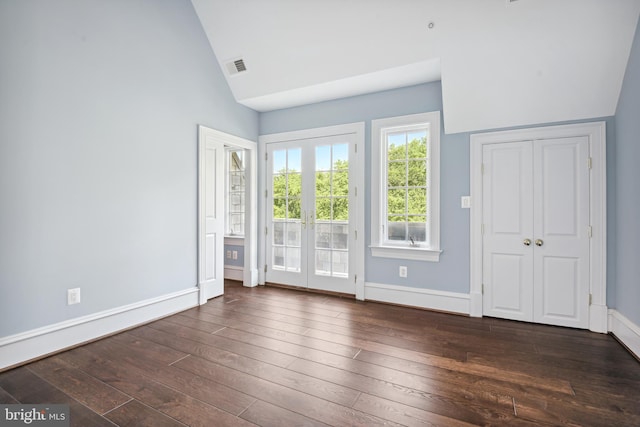 empty room with french doors, dark wood-type flooring, and lofted ceiling