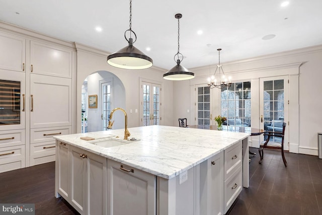 4825 Dexter Ter NW, Washington, DC 20007 - kitchen with a sink, arched walkways, a kitchen island with sink, french doors, and dark wood finished floors