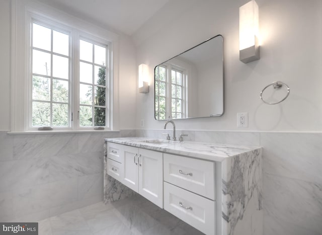 bathroom featuring vanity and tile walls