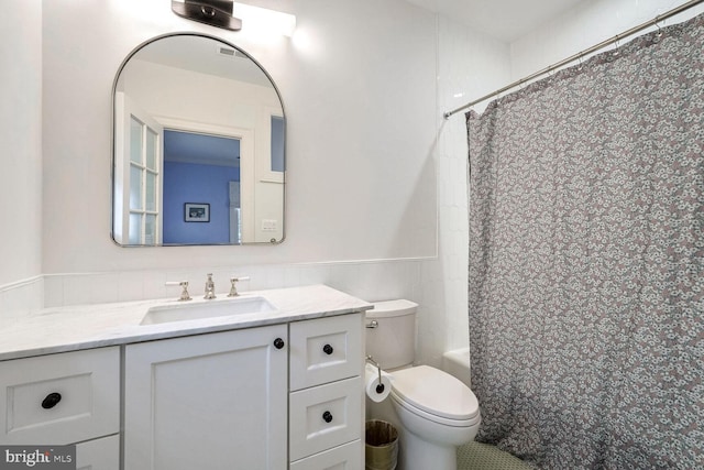 bathroom with a shower with shower curtain, vanity, and toilet