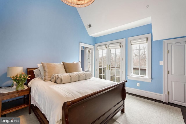 bedroom featuring high vaulted ceiling and french doors