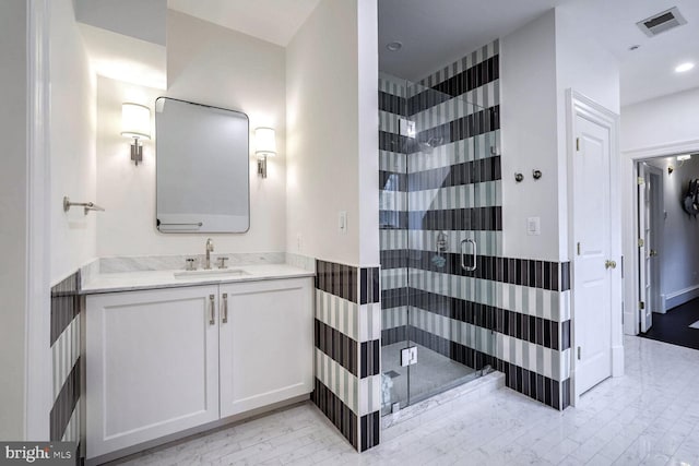 bathroom featuring vanity and a shower with door