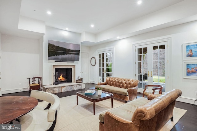 living room featuring wood-type flooring, baseboard heating, and french doors