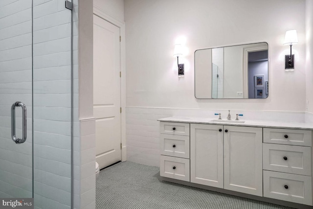 bathroom with tile patterned flooring, vanity, an enclosed shower, and tile walls