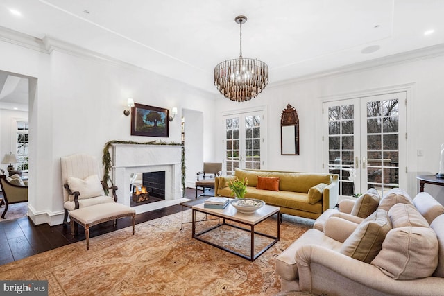 4825 Dexter Ter NW, Washington, DC 20007 - living room featuring hardwood / wood-style floors, a chandelier, crown molding, a warm lit fireplace, and baseboards