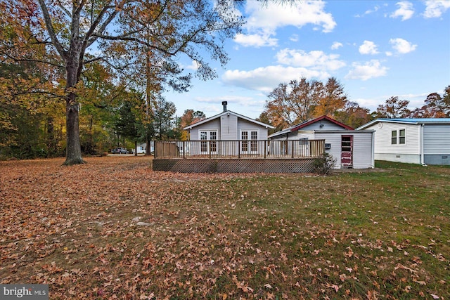 rear view of house with a lawn and a deck