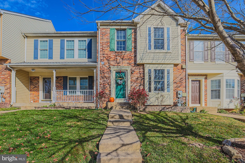 townhome / multi-family property featuring a front lawn