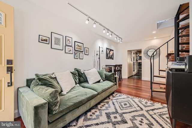 living room with dark hardwood / wood-style flooring and track lighting