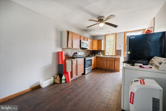 kitchen featuring tasteful backsplash, appliances with stainless steel finishes, sink, dark wood-type flooring, and ceiling fan