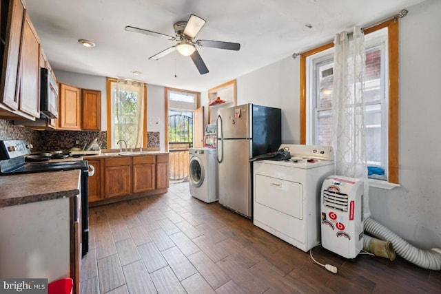 kitchen featuring washer / dryer, decorative backsplash, appliances with stainless steel finishes, and dark hardwood / wood-style flooring