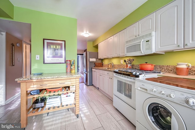 kitchen featuring washer / clothes dryer, sink, light hardwood / wood-style floors, white cabinets, and white appliances