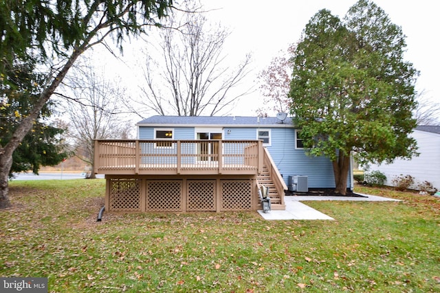 back of house with central air condition unit, a yard, and a wooden deck