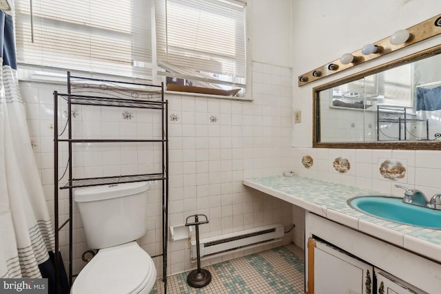 bathroom featuring tile patterned flooring, vanity, a baseboard heating unit, toilet, and tile walls