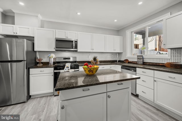 kitchen with white cabinetry, backsplash, and appliances with stainless steel finishes