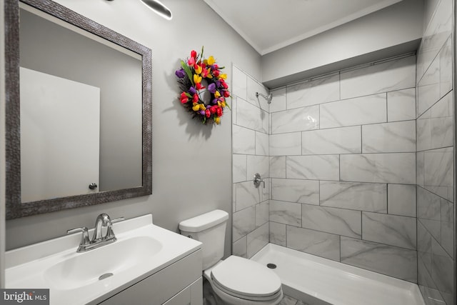 bathroom featuring tiled shower, toilet, and vanity