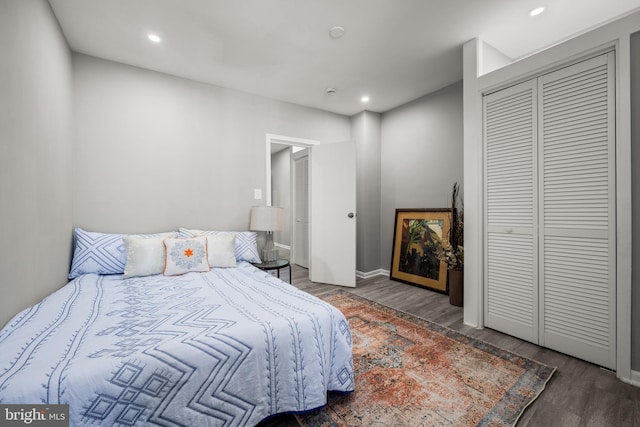 bedroom with dark wood-type flooring and a closet