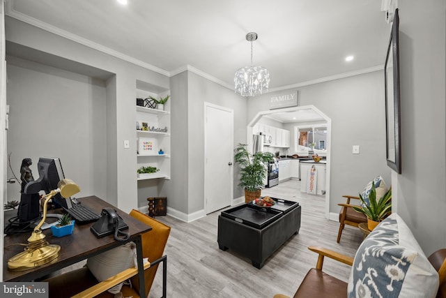 living room featuring ornamental molding, light hardwood / wood-style floors, built in features, and an inviting chandelier