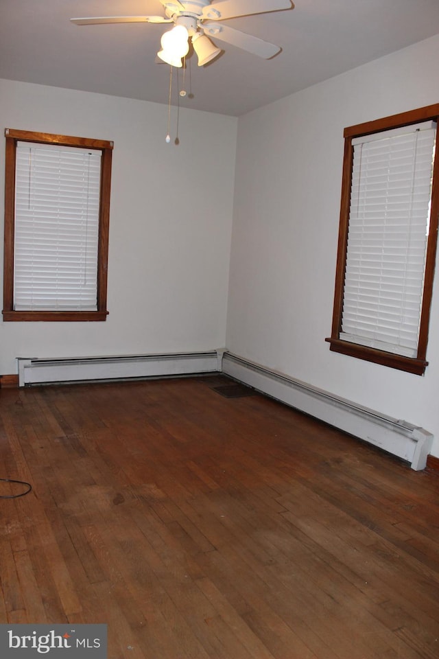 unfurnished room with ceiling fan, a baseboard heating unit, and dark hardwood / wood-style flooring