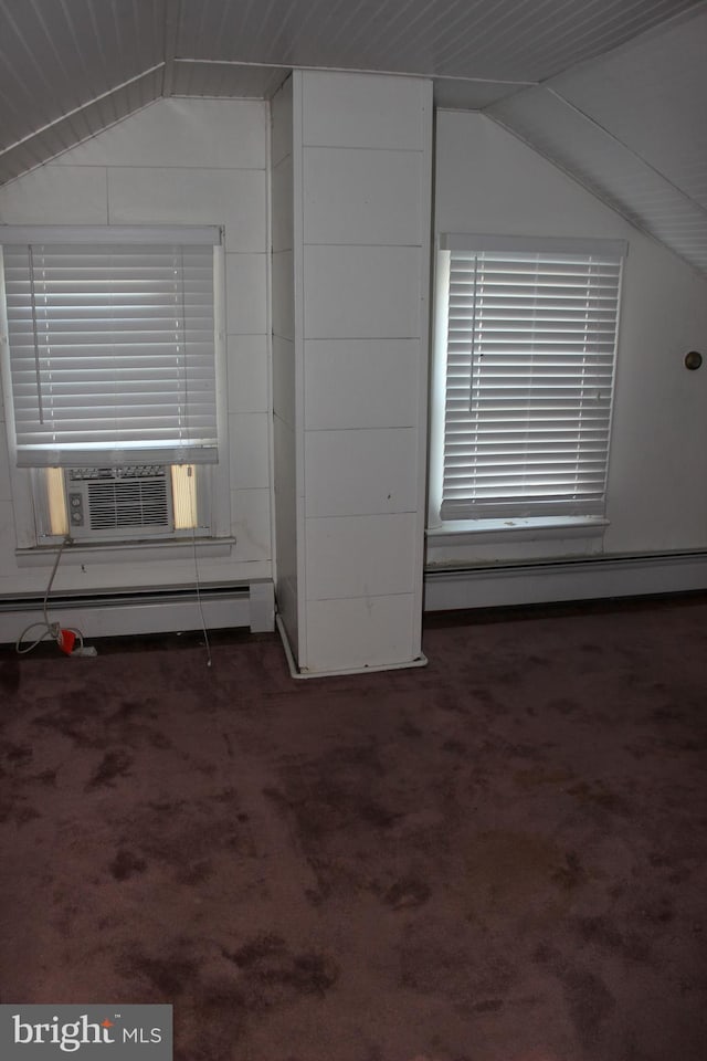 additional living space featuring dark colored carpet, cooling unit, a baseboard heating unit, and vaulted ceiling