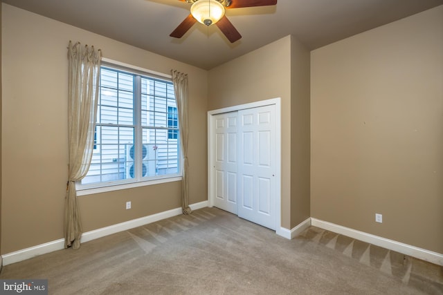 unfurnished bedroom featuring ceiling fan, a closet, and light colored carpet