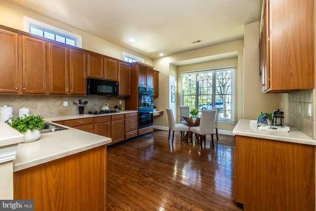 kitchen with black appliances, dark hardwood / wood-style flooring, a wealth of natural light, and tasteful backsplash