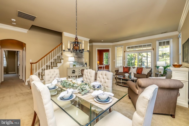 carpeted dining room featuring crown molding and a chandelier