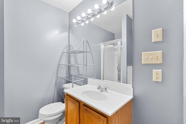 bathroom with a shower with door, vanity, and toilet