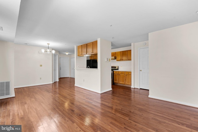 unfurnished living room featuring dark hardwood / wood-style flooring and a notable chandelier