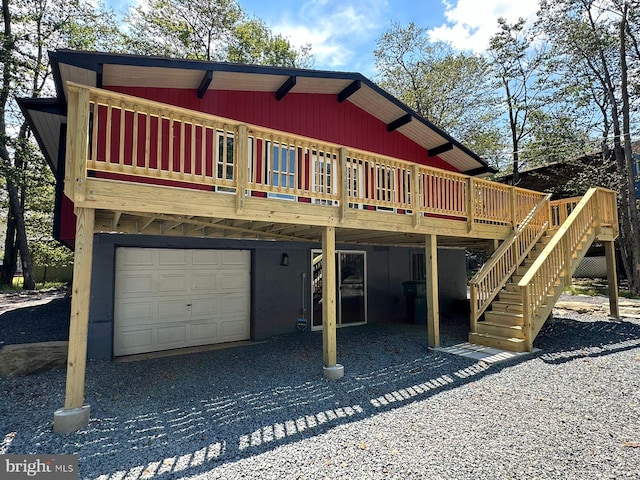 back of house with a wooden deck and a garage