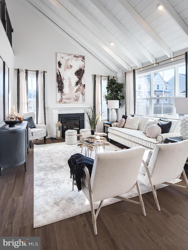 living room featuring plenty of natural light, dark wood-type flooring, vaulted ceiling with beams, and wooden ceiling